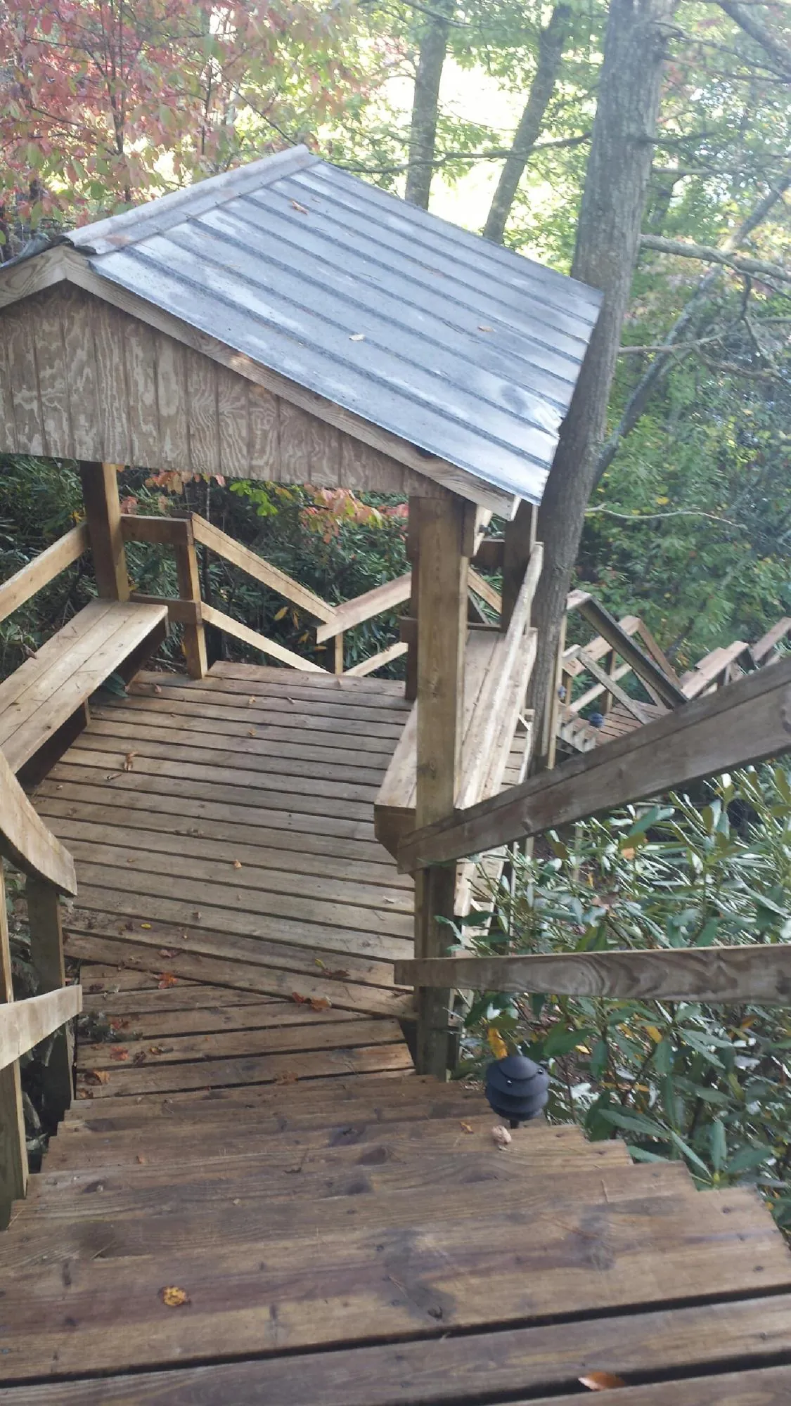 Metal roofed shelter over wooden steps on a wooded walkway — Skylight Repair & Installation work by our crew in Westville